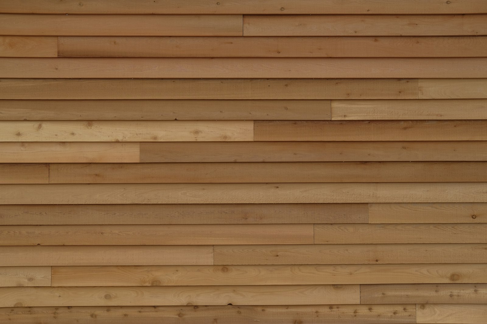 Close-up of natural cedar wood siding boards showing grain and color variation